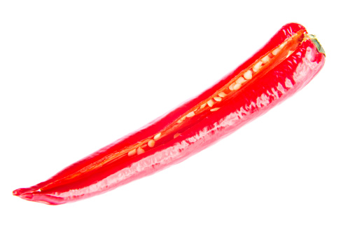 One separated chili pepper cut through lenght. Isolated on white.