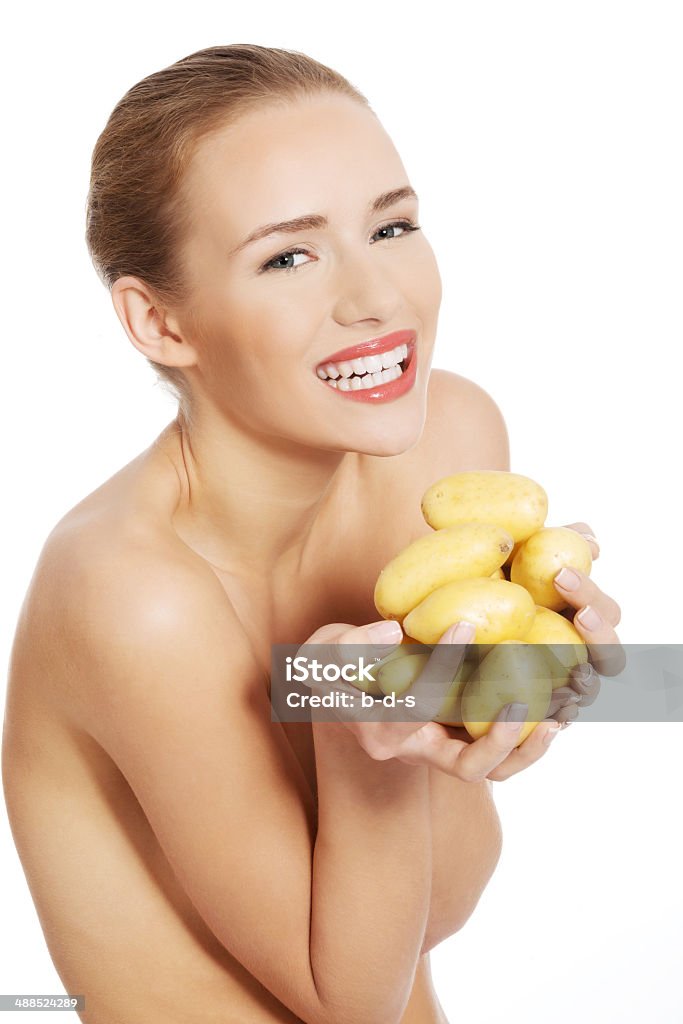 Bellissima nuda caucasica donna tiene fresco, patate crudo. - Foto stock royalty-free di Maturo
