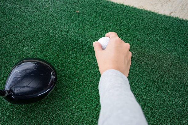 istock Close-up Hand holding golf ball and a golf wood 488524700