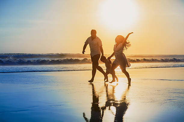 istock Positive family running with fun on the sunset beach 488527828