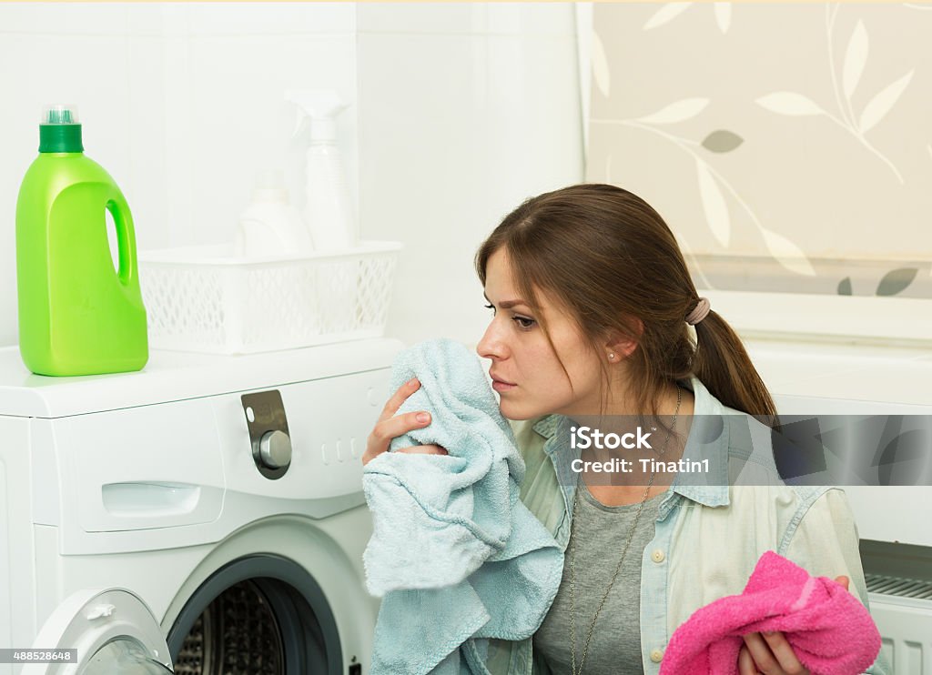 Beautiful girl doing laundry Beautiful young girl doing laundry at home Clothing Stock Photo