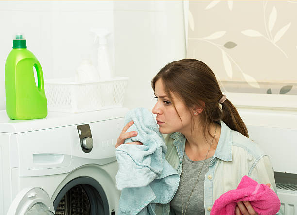 Beautiful girl doing laundry Beautiful young girl doing laundry at home fabric softener photos stock pictures, royalty-free photos & images