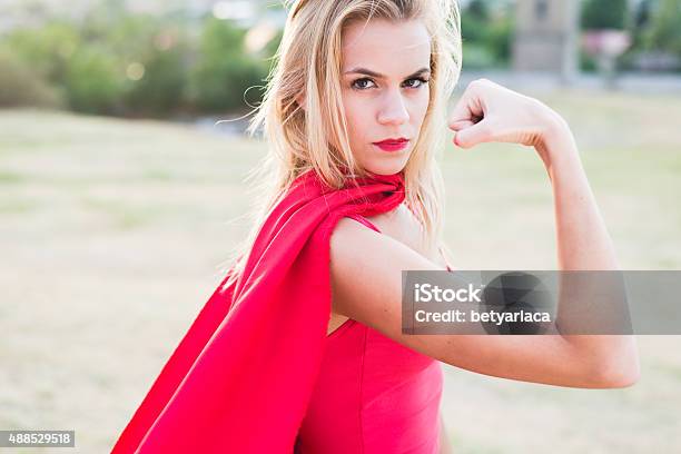 Young Blonde Woman Looking At Camera And Show Biceps Stock Photo - Download Image Now