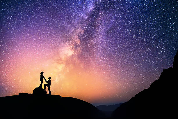 Love is in the air Romantic couple standing together holding hands in the mountains. Beautiful Milky Way galaxy on the background. annapurna range photos stock pictures, royalty-free photos & images