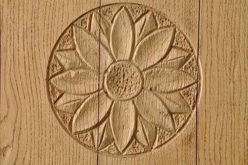 Floral wooden rosette on brown door as background