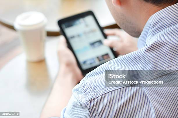 Man Using Tablet Pc Blurred Screen In Coffee Shop Stock Photo - Download Image Now - Digital Tablet, Men, Over The Shoulder View