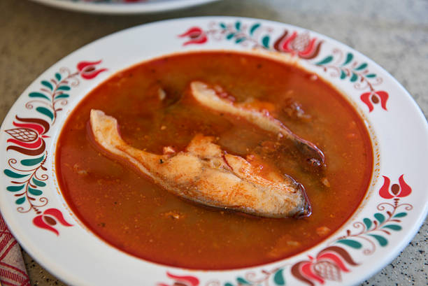 Fish soup chowder hungarian style Fish soup near at Tihany city, Lake Balaton, Hungary, august of 2015. Red paprika is a national attribute of many good hungarian dishes. Fish types can have a long variety. The plate is ornamental tulip pattern, traditional hungarian folk design. hungarian culture stock pictures, royalty-free photos & images