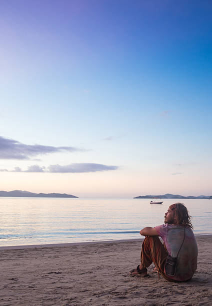 istock Young man standing on coastline and enjoying beautiful sunset over 488533012