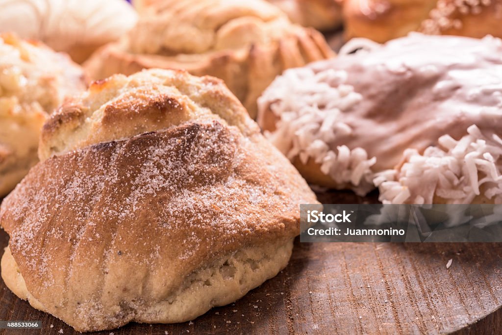 Mexican Pan Dulce (mexican sweet breads) Pan dulce ("sweet bread") is one of the poster treats in Mexico and other Latin American countries. One of the first non-native foods that was introduced to Mexico by Spain was wheat, a Spanish religious necessity. The creation of sweet bread was influenced by the French and Spaniards who were the ones that introduced baked goods such as crispy rolls, baguettes, and sweet pastries to Mexico. This inspired the indigenous peoples to create different types of pan dulces such as besos, conchas, and cuernos amongst others. The bread is considered to be one of Mexico's most inexpensive treats and is consumed daily as breakfast or late supper, known as merienda 2015 Stock Photo