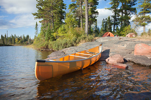 rocky campsite e canoas na costa do lago - boundary waters canoe area imagens e fotografias de stock