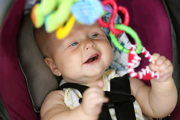 feliz niña bebé jugando en coche asiento de seguridad - 5 month old fotografías e imágenes de stock