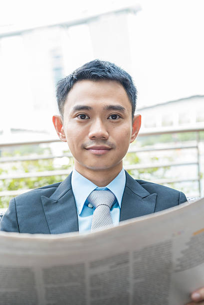 istock Asian Business man reading a newspaper 488536542