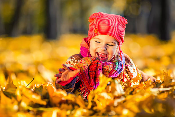istock Little girl playing with autumn leaves 488536666