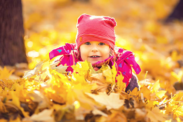 istock Little girl playing with autumn leaves 488536676