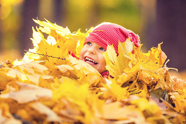 istock Little girl playing with autumn leaves 488536682