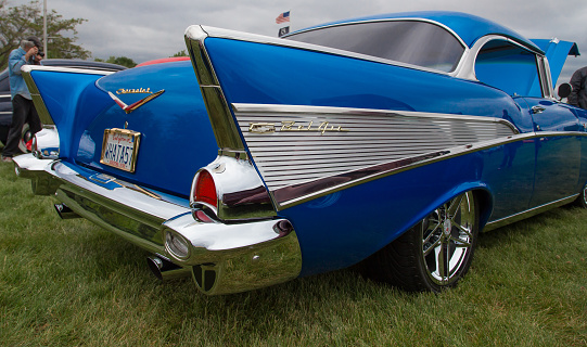 Redding, California, USA- April 2t, 2014: The back end of the popular 1957 Chevy Bel Air  shows sharp angles and beautiful chrome and bright blue paint while  on display at the Kool April Nights auto show in this northern California city.