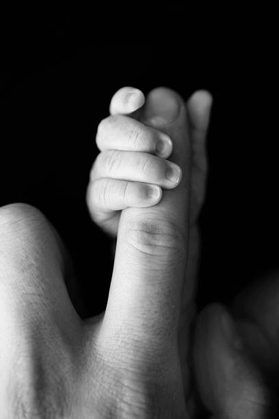 istock Newborn Hand Gripping Dad's Finger 488543050