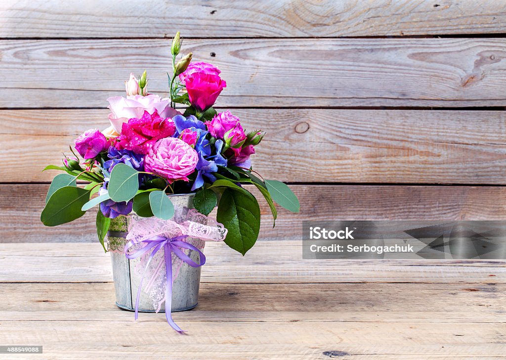 flowers. bouquet of roses on a wooden background flowers. bouquet of roses in a bucket on a white wooden background 2015 Stock Photo