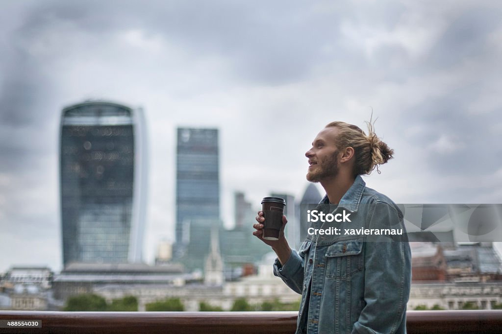 Pensive hipster drinking coffee in the street at London Pensive hipster drinking coffee in the street at London. City Stock Photo