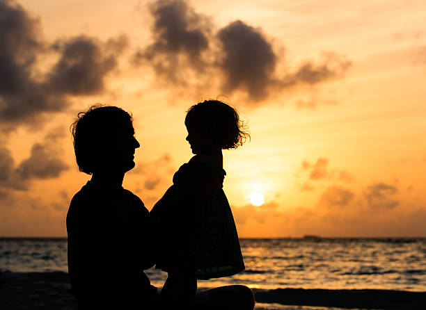 istock Father and little daughter on beach at sunset 488554688