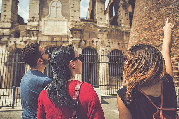 turistas com guia na frente do coliseu, roma - flavian amphitheater fotos imagens e fotografias de stock