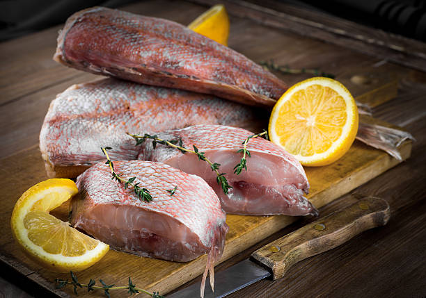 istock Sea bass with lemon on wooden board 488556867