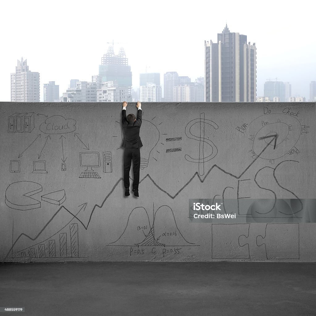 Man climbing over wall with business doodles Man climbing over wall with business doodles and city view background Adult Stock Photo