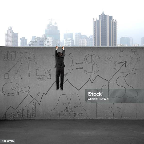 Man Climbing Over Wall With Business Doodles Stock Photo - Download Image Now - Adult, Arrow - Bow and Arrow, Black Color