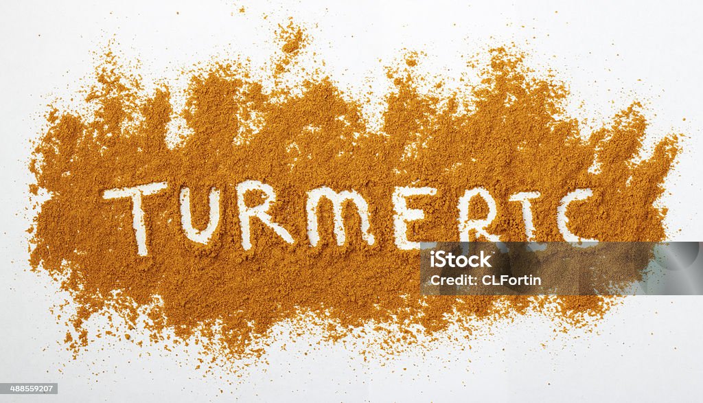 Turmeric powder Turmeric powder sprinkled on a natural background. The word turmeric is spelled out across the powdered surface. Turmeric Stock Photo