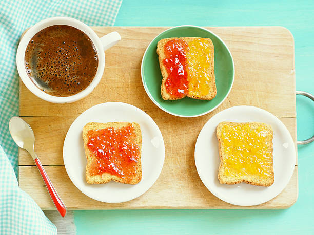 Toast with jam Zwiebacks with jam and cup of coffee for continental breakfast on wooden trencher zwieback toast stock pictures, royalty-free photos & images