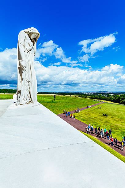 Vimy Ridge Memorial, Mother Canada Vimy, France - July 29, 2015: Visitors attending the Vimy Memorial to Canadian soldiers killed during the conflict in World War One at Vimy Ridge in France. The statue, known as Mother Canada, or as Canada Bereft, head bowed and facing east towards the morning sun, commemorates the 11,285 missing Canadian soldiers with no known graves. The site and its monument has been designated a Canadian National Historic Site and is administered by the Historic Sites and Monuments Board of Canada. vimy memorial stock pictures, royalty-free photos & images