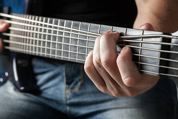 istock male musician playing on six-string bass guitar 488562690