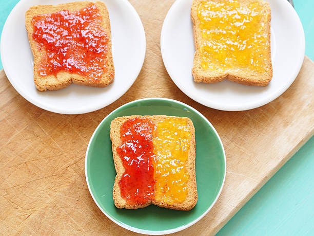 Toast with jam Zwiebacks with apricot and strawberry jam for continental breakfast zwieback toast stock pictures, royalty-free photos & images