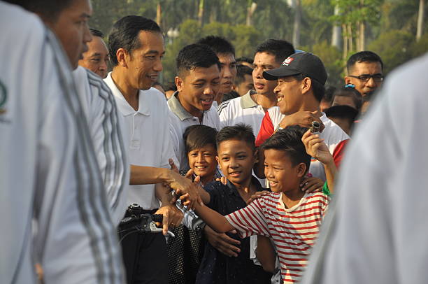 Joko Widodo Jakarta, Indonesia - November 23, 2014: President of Indonesia Joko Widodo shaking hands with the children in the area of the National Monument, Jakarta, Indonesia. association of southeast asian nations photos stock pictures, royalty-free photos & images