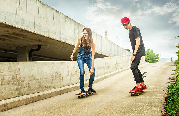istock Skateboarder woman and man rolling down the slope 488566136