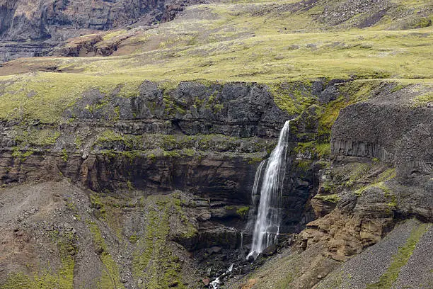 Waterfall in Iceland falling of a cliff into a canyon in Iceland to the Fossa river, a tributary of Thjorsa, close to the Haifoss waterfall.