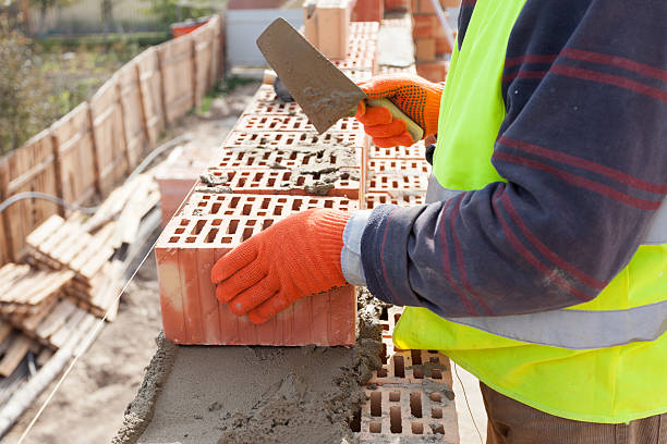 istock Worker bricklayer installing red brick with trowel putty knife outdoors 488569350