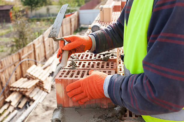 mason trabalhador pedreiro instalação de tijolo vermelho com uma faca colher de pedreiro pasta de cimento - mason brick bricklayer installing - fotografias e filmes do acervo