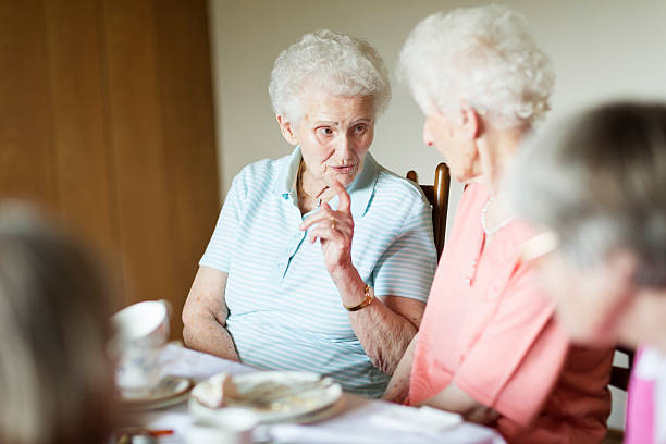 istock senior women conversation gossip 488572899