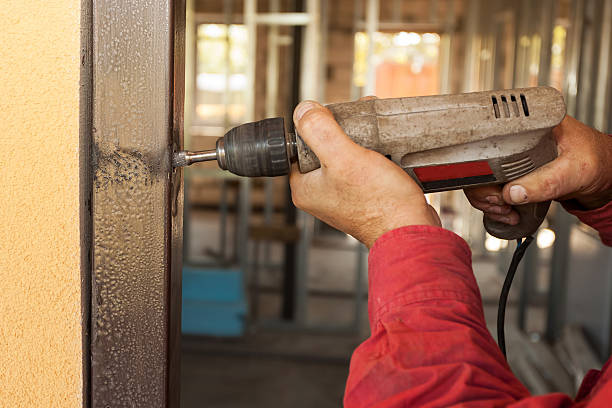 istock Carpenter at door installation with electric drill 488573594