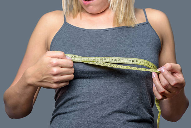 istock Young blond woman measuring her breast 488574028
