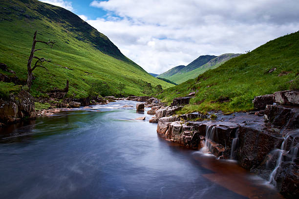 Stream going down a valley filled with fog  in the Glen Affric area of the Scottish Highlands.