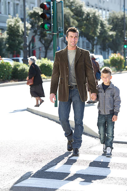 istock Father And Son Crossing The Cross Walk 488576175