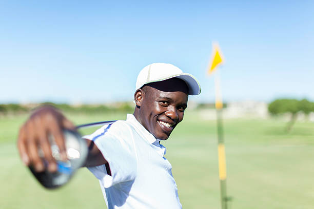 istock African golfer smiling, holding a golf club over his shoulder. 488576295