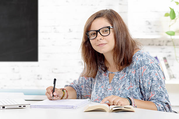 istock teenage girl  doing her homework in classroom 488576504