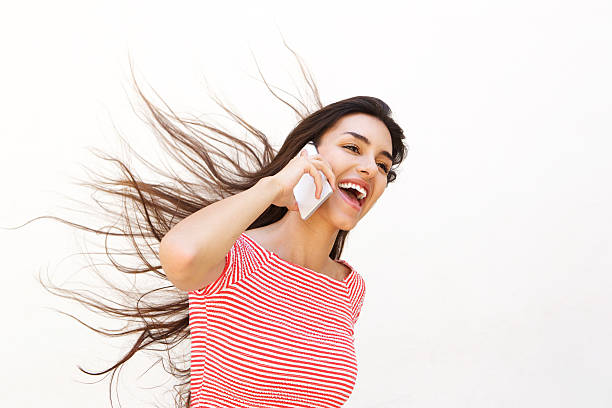 istock Teenager talking on mobile phone with wind blowing hair 488577200
