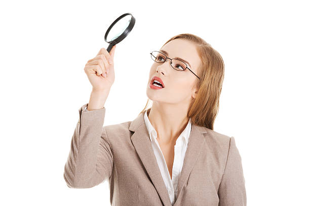 istock Beautiful business woman looking through magnifying glass. 488577385