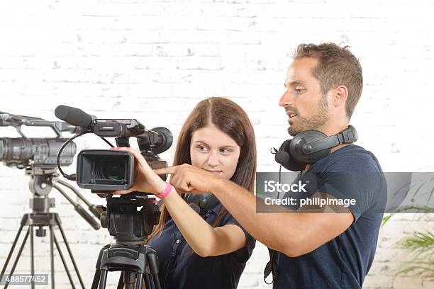 Cameraman And A Young Woman With A Movie Camera Stock Photo - Download Image Now - Home Video Camera, Teamwork, Assistant