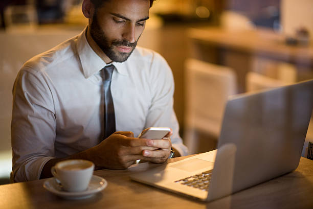 istock Man sitting in coffee shop and texting message 488577606