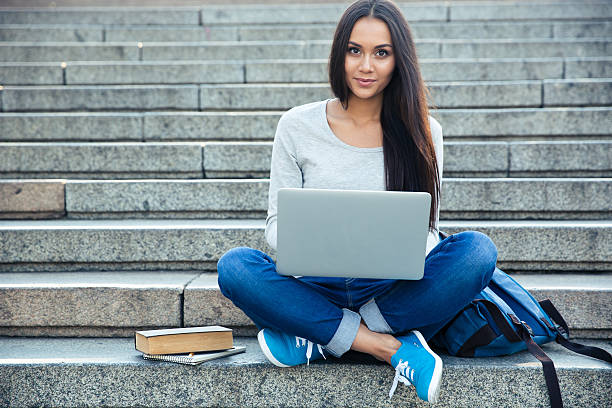 istock Happy woman using laptop computer outdoors 488579344
